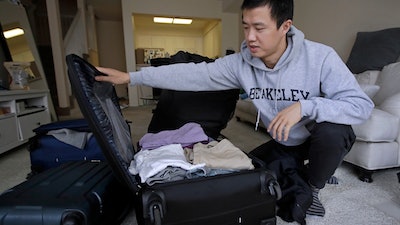 In this Feb. 4, 2019, photo, Leo Wang packs a suitcase at his home in San Jose, Calif. Wang has found himself trapped in an obstacle course regarding H-1B work visas for foreigners. His visa denied and his days in the United States numbered, A federal judge on Thursday, Oct. 1, 2020, temporarily lifted a visa ban on a large number of work permits, undercutting a measure that the Trump administration says will protect American jobs in a pandemic-wracked economy.