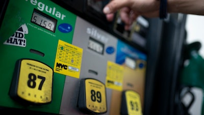 Wallace Reid purchases fuel for the vehicle he drives to make a living using ride-share apps, Wednesday, June 22, 2022, in the Queens borough of New York.