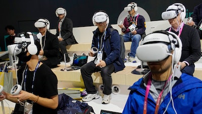 Attendees wear VR headsets while previewing the Caliverse Hyper-Realistic Metaverse experience at the Lotte booth during the CES tech show Friday, Jan. 6, 2023, in Las Vegas.