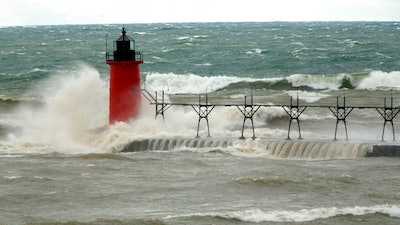 In this April 6, 2017 file photo, strong winds send huge waves at the Lake Michigan shoreline at South Haven Michigan. A decade-old program that has pumped $2.7 billion into healing long-term injuries to the Great Lakes environment has received authorization from Congress to continue another five years. The U.S. Senate voted unanimously Sunday, Dec. 20, 2020, to extend the Great Lakes Restoration Initiative, which the House did earlier this year.