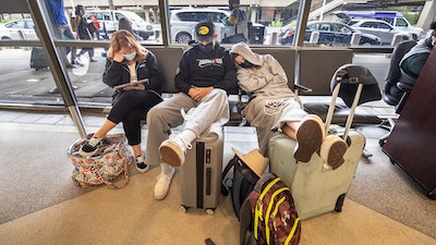 Stranded travelers sleep on the seats of the ticketing waiting area, Tuesday, Aug. 3, 2021. at Philadelphia International Airport in Philadelphia.