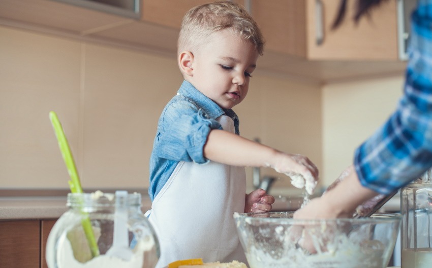 toddler making a gift by baking