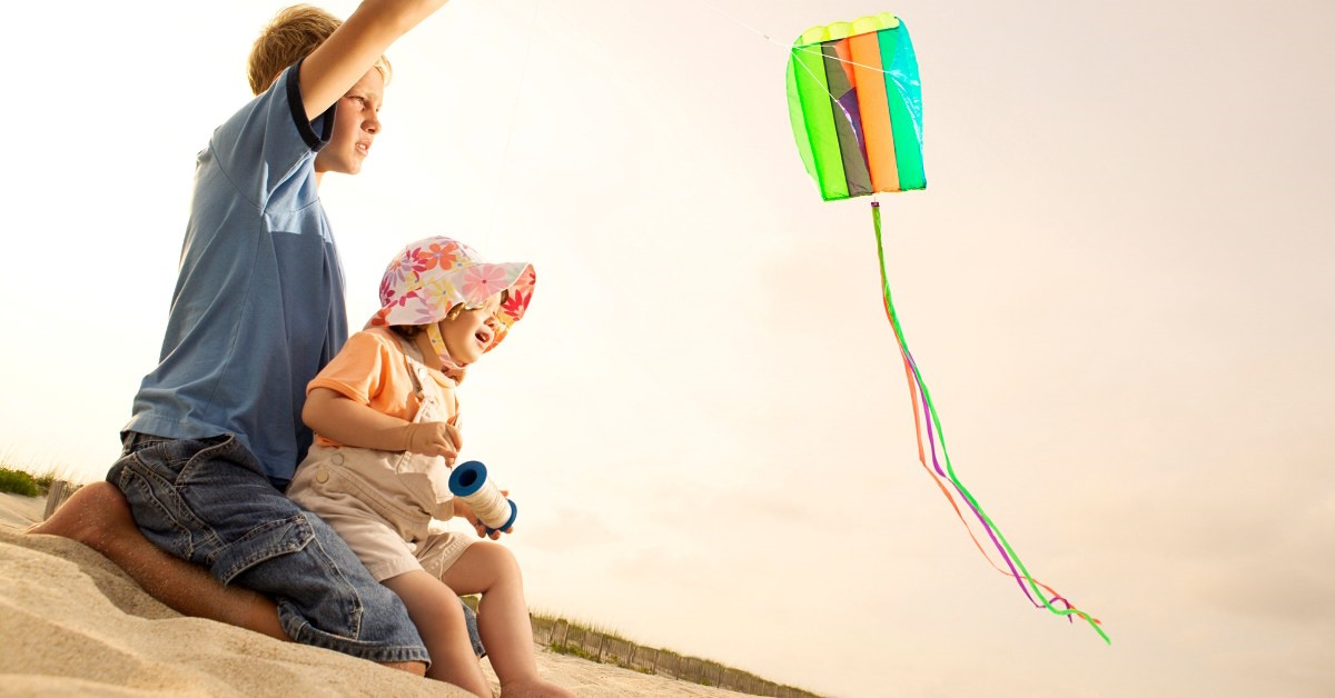 toddler flying a kite at the beach