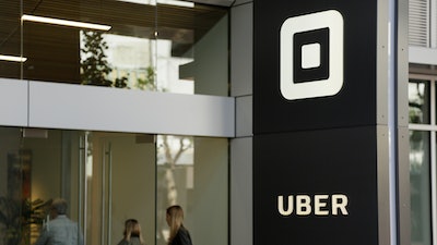 In this June 21, 2017, file photo, people make their way into the building that houses the headquarters of Uber in San Francisco. A federal commission said Wednesday, Dec. 18, 2019, that Uber Technologies, Inc. will establish a $4.4 million fund for employees who experienced sexual harassment while at the San Francisco ride-hailing company. The settlement ends an investigation by the U.S. Equal Employment Opportunity Commission launched in 2017 after a former Uber engineer detailed the harassment she experienced in a widely shared blog post.